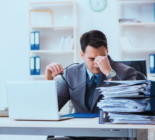 Frustrated business executive overwhelmed by paperwork